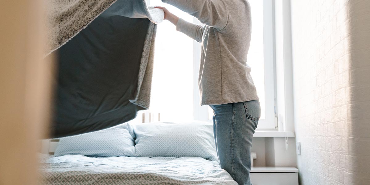 Eine Frau macht das Bett neu