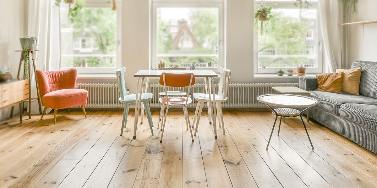 Sauberes helles Wohnzimmer mit einem Esstisch in der Mitte