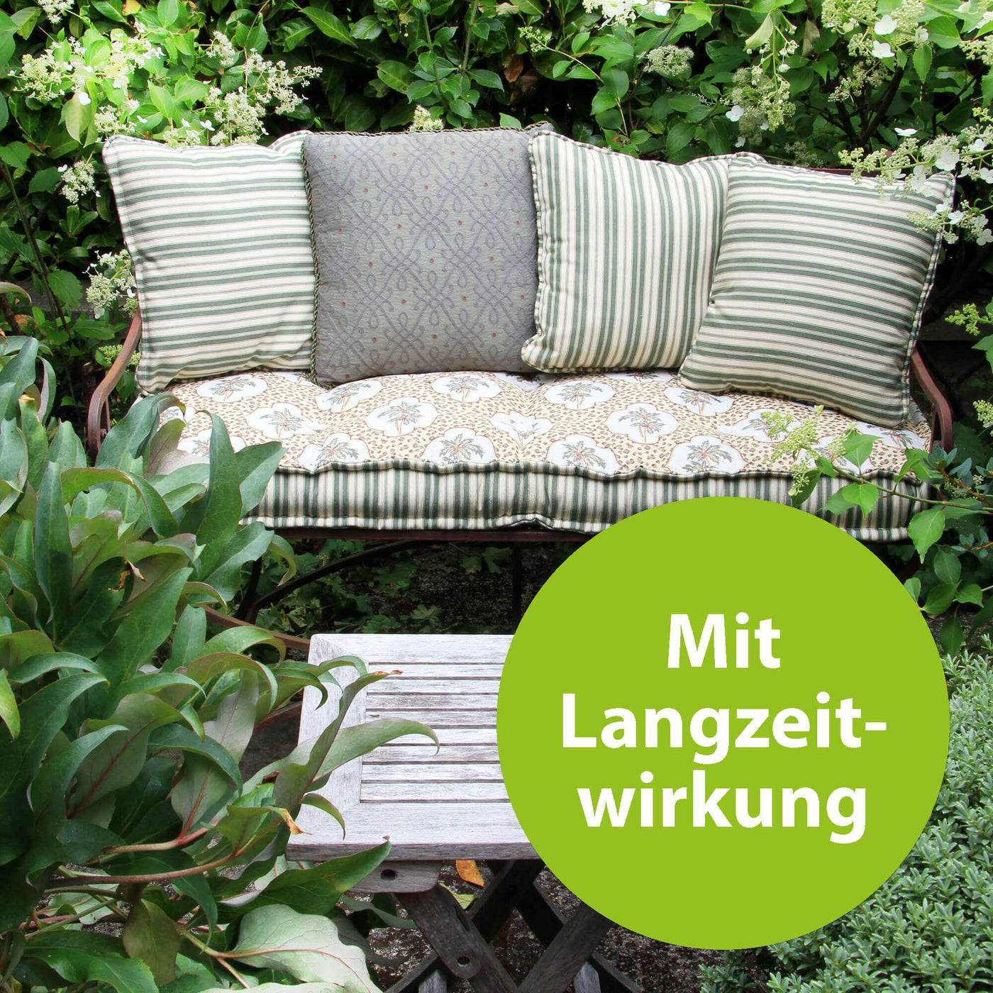 Grüner Garten mit einer Bank mit der Schrift "Mit Langzeitwirkung"